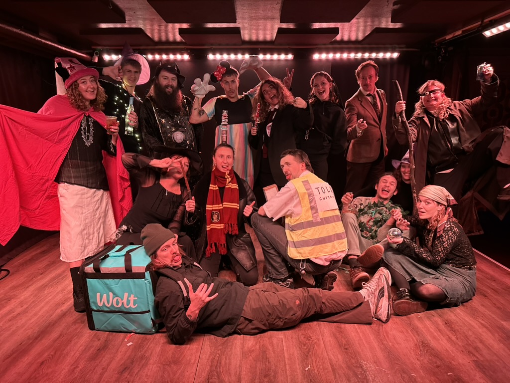 A group in costumes together on the stage at HQ